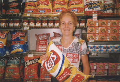 605956 Portret van een winkelierster in een levensmiddelenwinkel, vermoedelijk in de wijk Lombok te Utrecht.